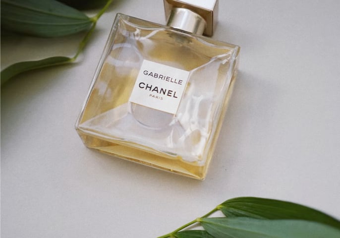 Bottle of perfume surrounded by leaves